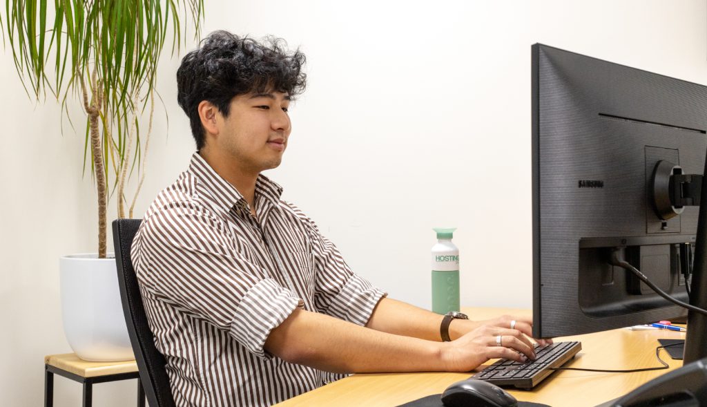 Een medewerker van de Hosting2GO helpdesk achter zijn beeldscherm