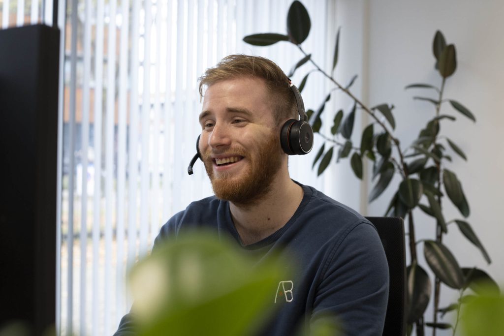 Een helpdeskmedewerker met headset aan het werk
